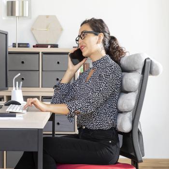 Frau nutzt das flexible Multifunktions-Kopfkissen Rollow InnovaGoods im Büro für ergonomisches Sitzen