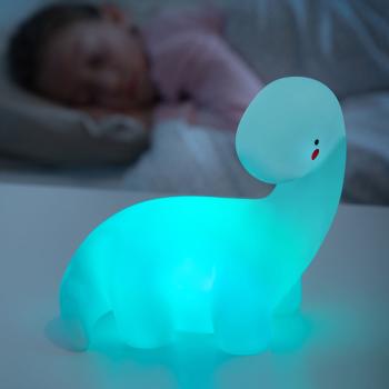 LED-Dinosaurierlampe Lightosaurus InnovaGoods auf dem Nachttisch, blau leuchtend als Nachtlicht im Kinderzimmer
