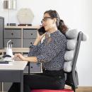 Frau nutzt das flexible Multifunktions-Kopfkissen Rollow InnovaGoods im Büro für ergonomisches Sitzen